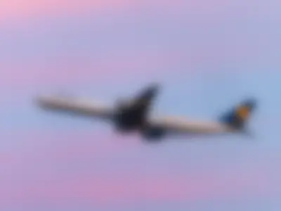 Lufthansa A340-600 climbing out against a pink evening sky